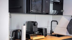 Una cocina moderna con cafetera, hervidor y organizador de cajones.
