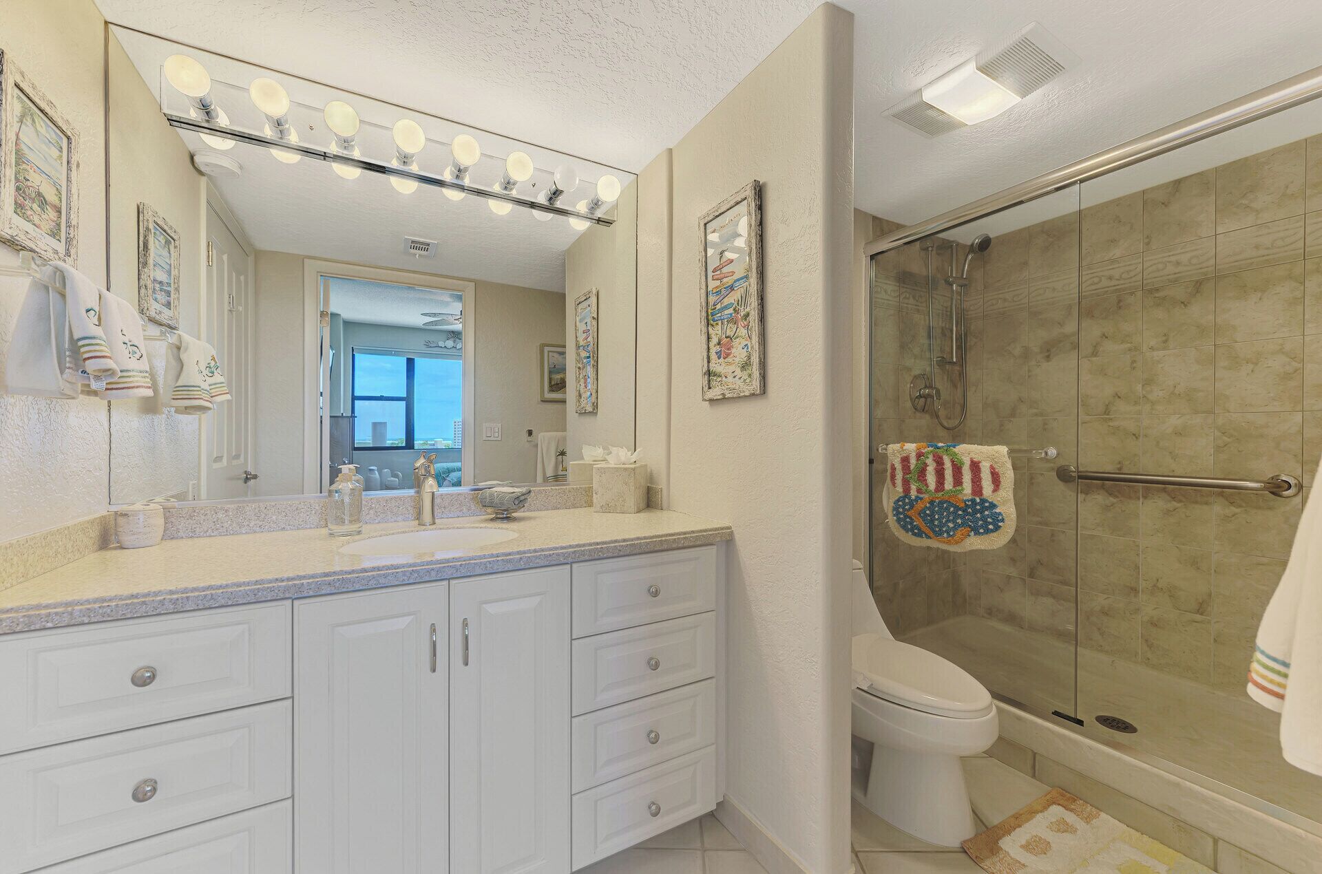A bathroom with a vanity, a shower, and a toilet.