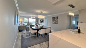 Un comedor moderno con encimera de mármol, un candelabro y un amplio ventanal con vistas al exterior.