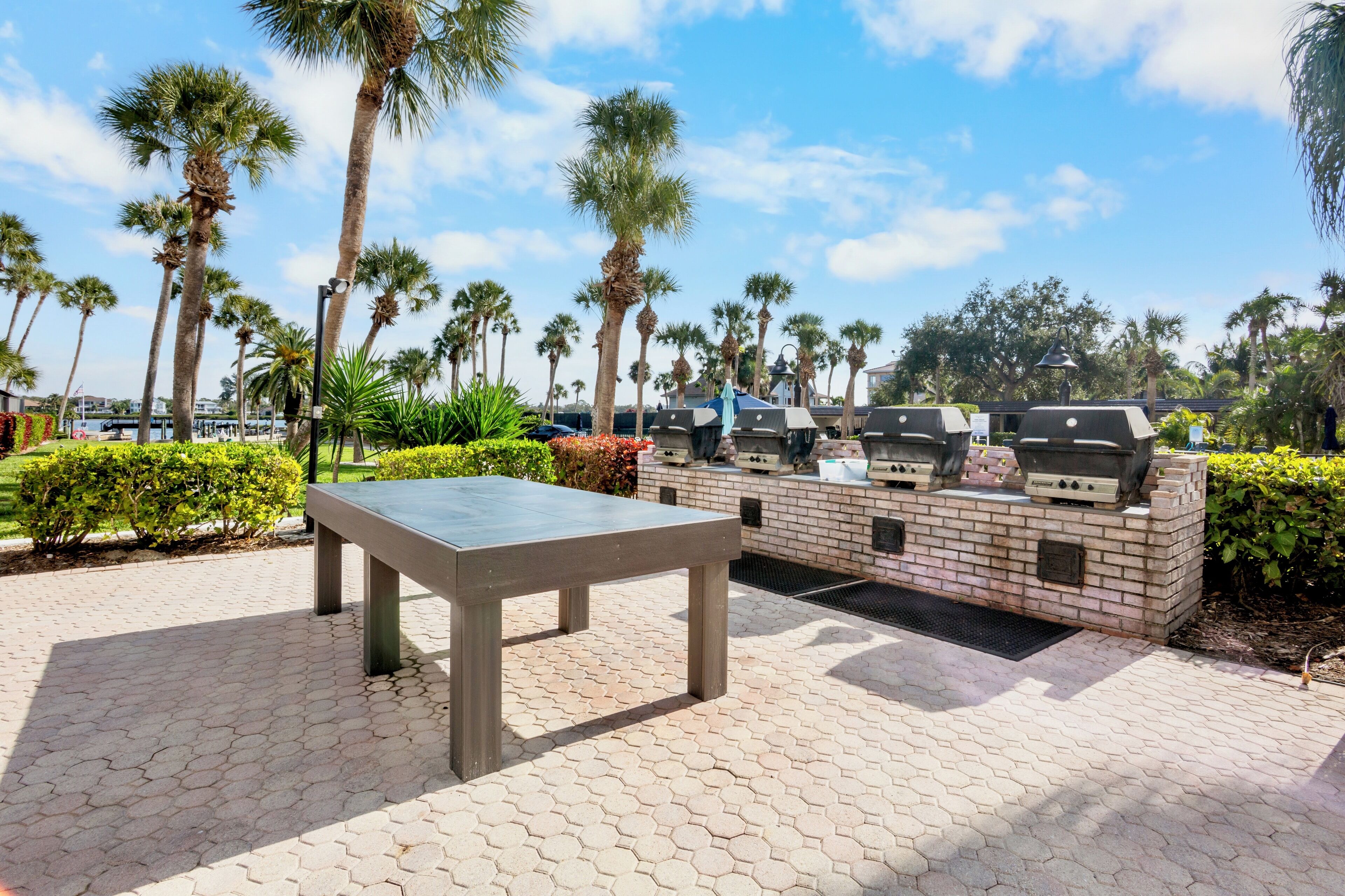 An outdoor patio with a table and barbecue grills.