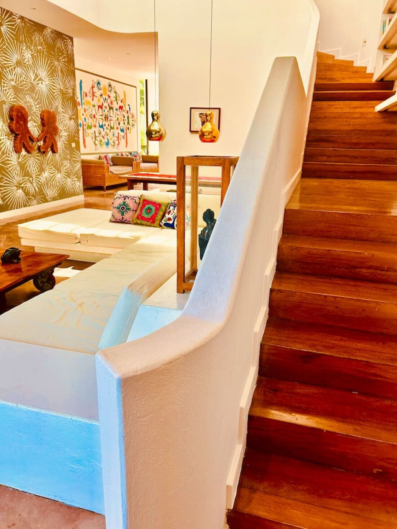 A modern living room with a wooden staircase, a sofa, and a coffee table.