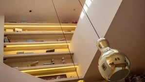 Um interior moderno com claraboia, vários níveis e luminárias pendentes.