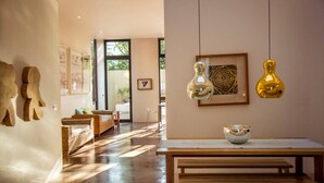 Um interior moderno com mobiliário de madeira, uma mesa de jantar e luminárias pendentes.