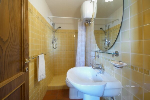 Un baño con ducha, lavamanos e inodoro.