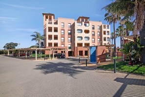 Un hôtel à plusieurs étages doté d’une cour intérieure, d’un espace extérieur aménagé pour s’asseoir et d’une zone couverte.
