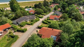 Área residencial com casas, uma rua e uma praia ao fundo.