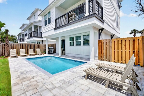 A two-story house with a swimming pool, outdoor seating, and a wooden fence. - Oceans East: Private heated pool, Free golf cart, 1 min beach, Game & Bunk rooms (Miramar Beach)
