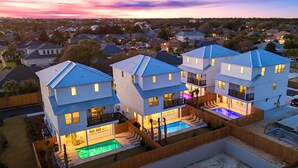 A modern multi-story residential building with a swimming pool, multiple balconies, and a fenced backyard. - Oceans East: Private heated pool, Free golf cart, 1 min beach, Game & Bunk rooms (Miramar Beach)