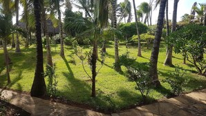 A lush garden with palm trees and a stone pathway.