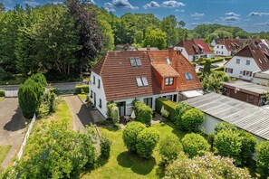 Et boligområde med huse, en velplejet græsplæne og forskellige træer.