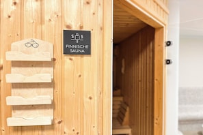 Een houten sauna met een bordje waarop staat dat het een Finse sauna is.