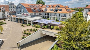 Un hotel con un cortile interno, posti a sedere all'aperto e una zona coperta.