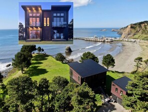 Una propiedad costera con una casa moderna de dos pisos, una edificación más pequeña y vista a la playa.