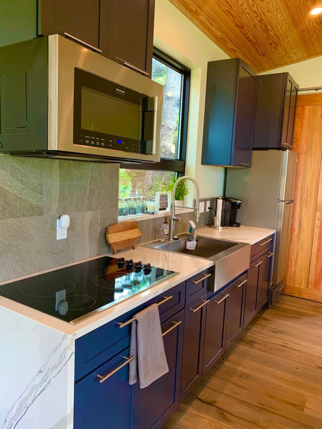 A modern kitchen with a built-in stove, microwave, and refrigerator.