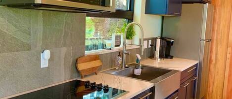 A modern kitchen with a built-in stove, microwave, and refrigerator.