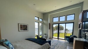 Een moderne slaapkamer met een groot bed, een bureau en uitzicht op de omgeving.