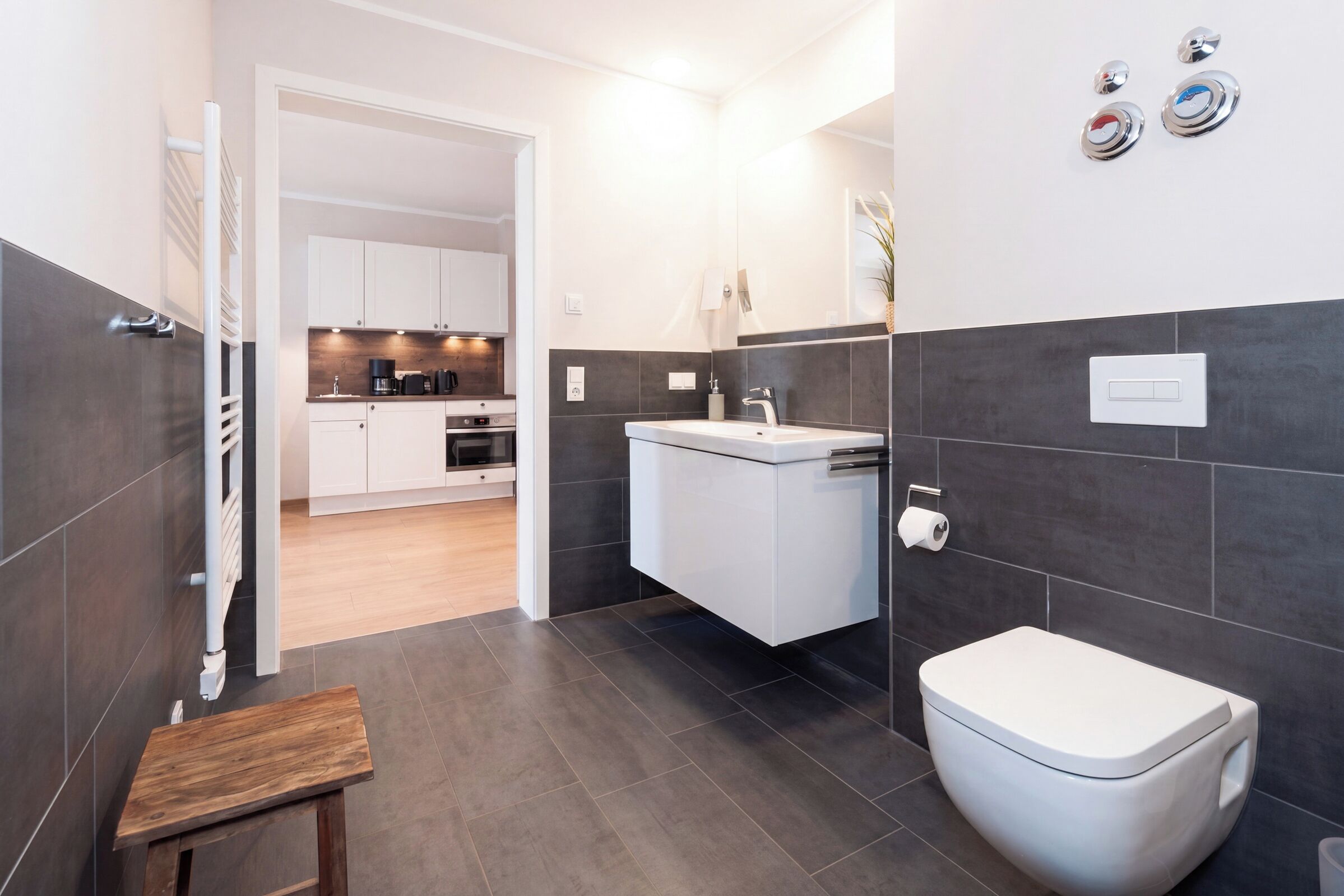 Ein modernes Badezimmer mit Toilette, Waschbecken und Duschbereich.