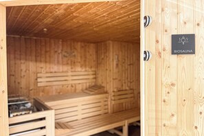 Ein hölzerner Saunaraum mit Bänken und einem Schild, das anzeigt, dass es sich um eine Biosauna handelt.