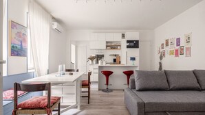 Ein modernes Wohnzimmer mit Essbereich, Küche und einer Couch.