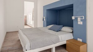 Ein Schlafzimmer mit einem Bett, einem Nachttisch aus Holz und einer blauen Akzentwand.