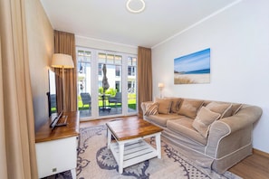 Ein Wohnzimmer mit einer Couch, einem Couchtisch, einer Lampe und einem Bild an der Wand.