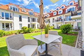 A courtyard with outdoor seating, a table, and a potted plant. - Baltischer Hof Apartment 09 (Ostseebad Boltenhagen)
