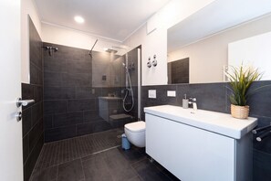 Ein modernes Badezimmer mit Dusche, Toilette und Waschbecken.