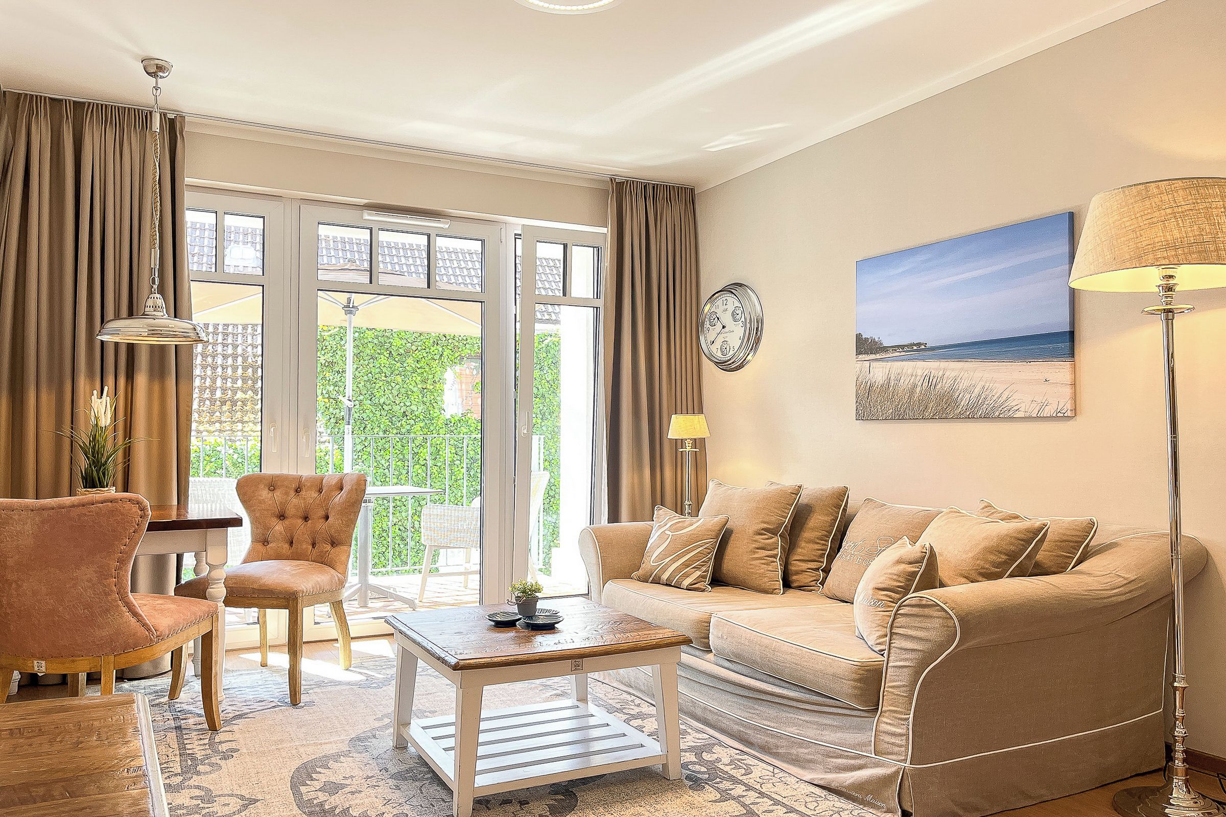 A living room with a sofa, armchairs, a coffee table, and a view of the outdoors.