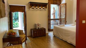 A room with a bed, a small table with fruit, a wooden cabinet, and a view of a balcony. - DUOMO, your private garden in TORRE: THE SFINGE OF THE SECRET GARDEN. (Firenze)