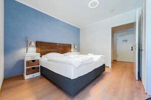Une chambre à coucher moderne avec un lit, des tables de chevet et une armoire.