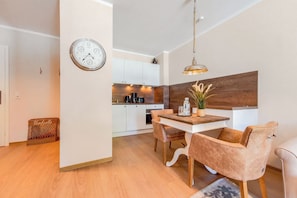 Eine moderne Küche mit weißen Schränken, einer Holz Arbeitsplatte und einer hängenden Pendelleuchte.
