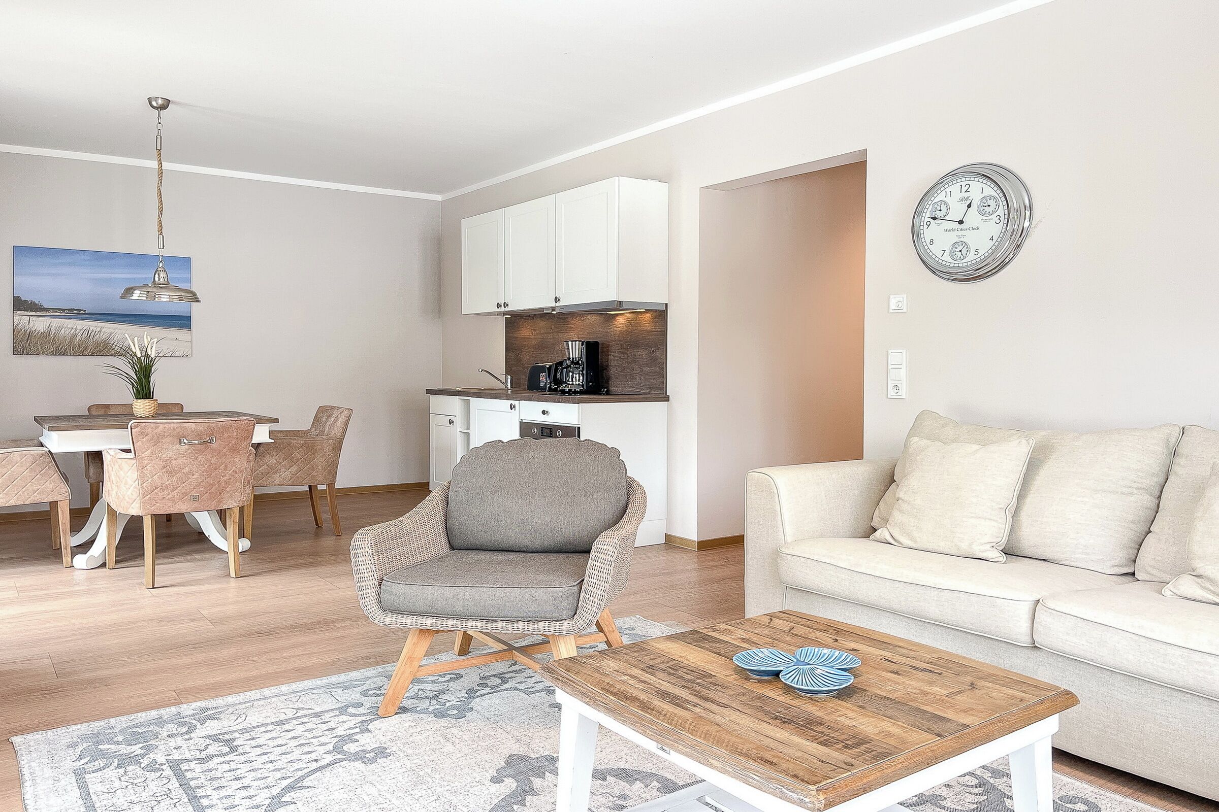 A modern living room with a grey armchair, a wooden coffee table, and a beige sofa.