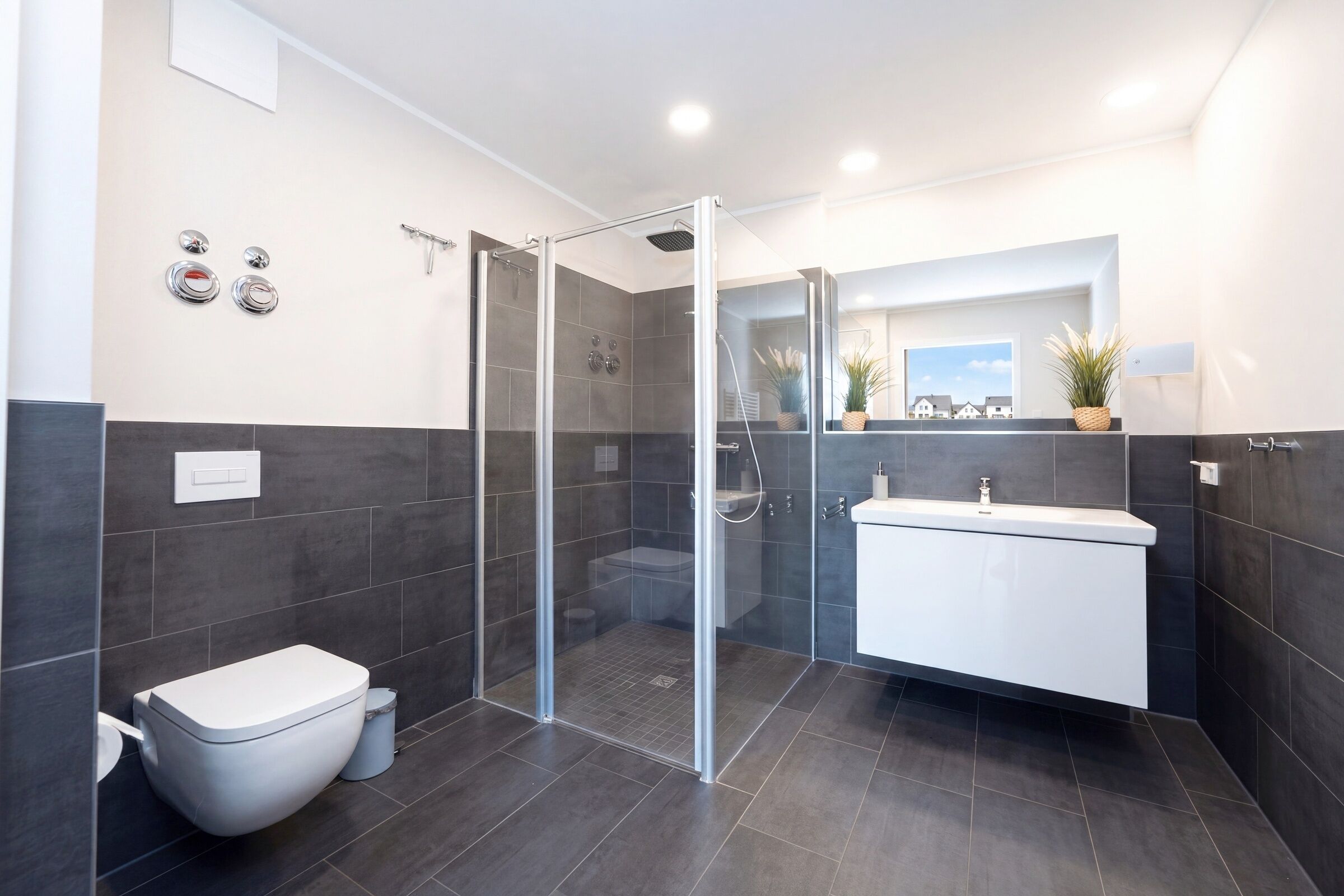 A modern bathroom with a glass-enclosed shower, a toilet, and a white vanity.