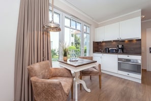 Eine moderne Küche mit weißen Schränken, einer Holz Arbeitsplatte und einem eingebauten Ofen.