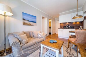Ein Wohnzimmer mit einer Couch, einem Couchtisch, einer Lampe und einem Gemälde an der Wand.