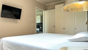 Una camera da letto con un letto, una televisione a muro e un armadio con ante scorrevoli.