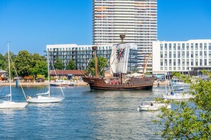 A large sailing ship docked at a marina with modern buildings in the background. - Promenade Villa 03 Apartment 05 (Lübeck-Travemünde)