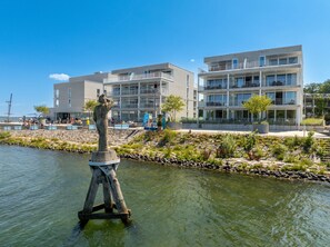 A modern building with multiple balconies and a statue in the foreground. - Promenade Villa 03 Apartment 05 (Lübeck-Travemünde)