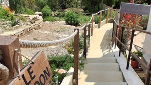 Eine Betontreppe mit einem Holzgeländer, das zu einem Schild mit der Aufschrift 'LE COCON' führt.