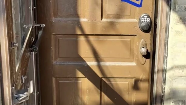 Una puerta de madera con cerradura electrónica y mirilla.
