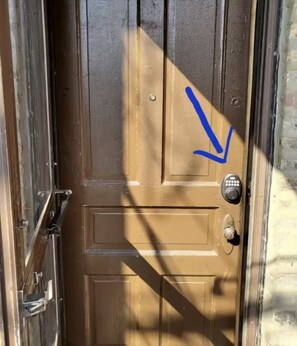 Una puerta de madera con cerradura electrónica y mirilla.