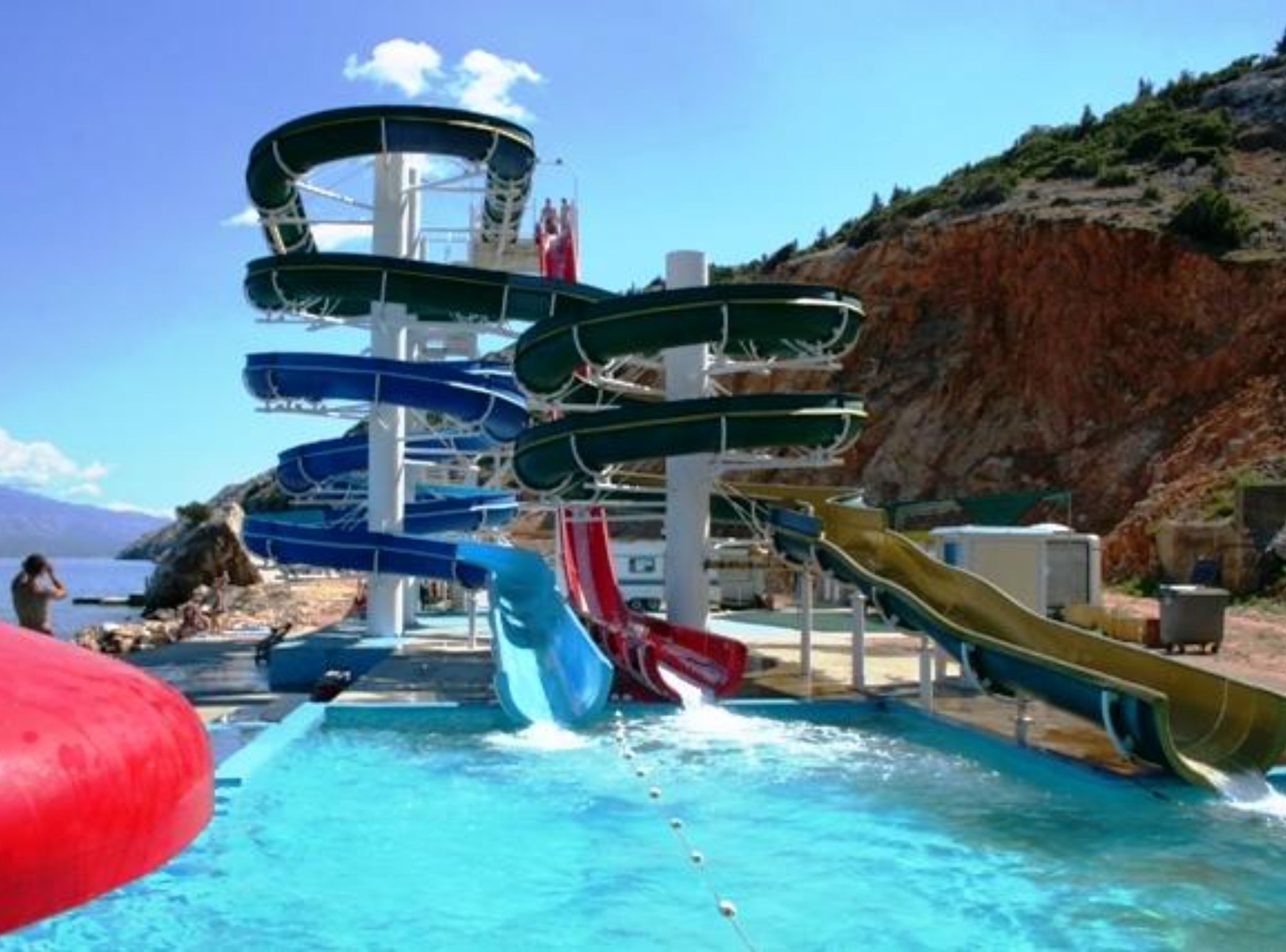 A water park with multiple slides and a pool.