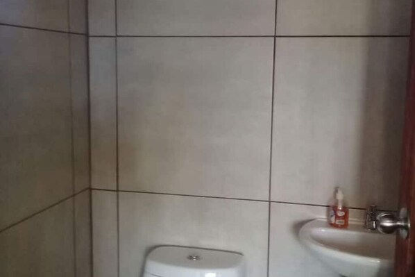 A bathroom with a toilet and a sink.