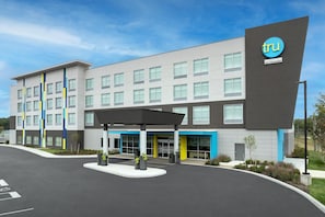A modern hotel building with a prominent 'tru' logo, a covered entrance, and a landscaped area with planters. - Tru By Hilton Valparaiso (Valparaiso)