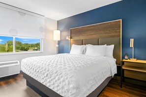 A modern hotel room with a large bed, a view of greenery outside, and a built-in heater. - Tru By Hilton Valparaiso (Valparaiso)