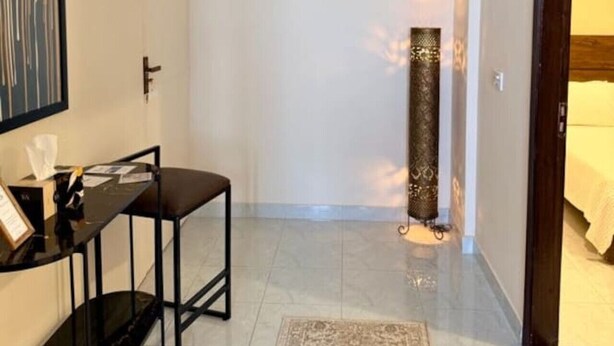 Camera d'albergo con scrivania, sedia e tappeto decorato.
