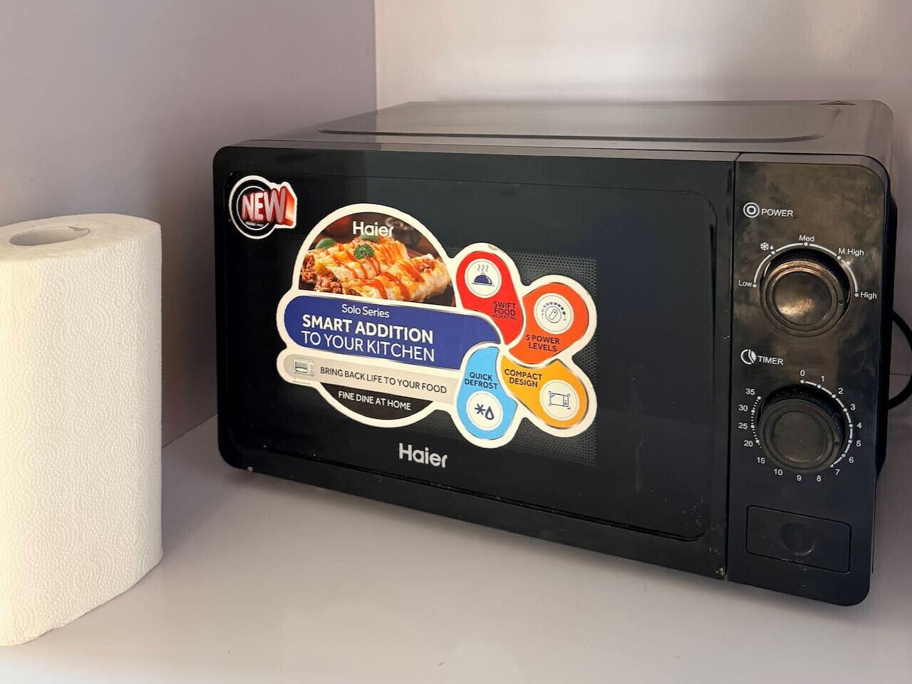 A Haier Solo Series microwave with a digital display, power levels, and timer settings.