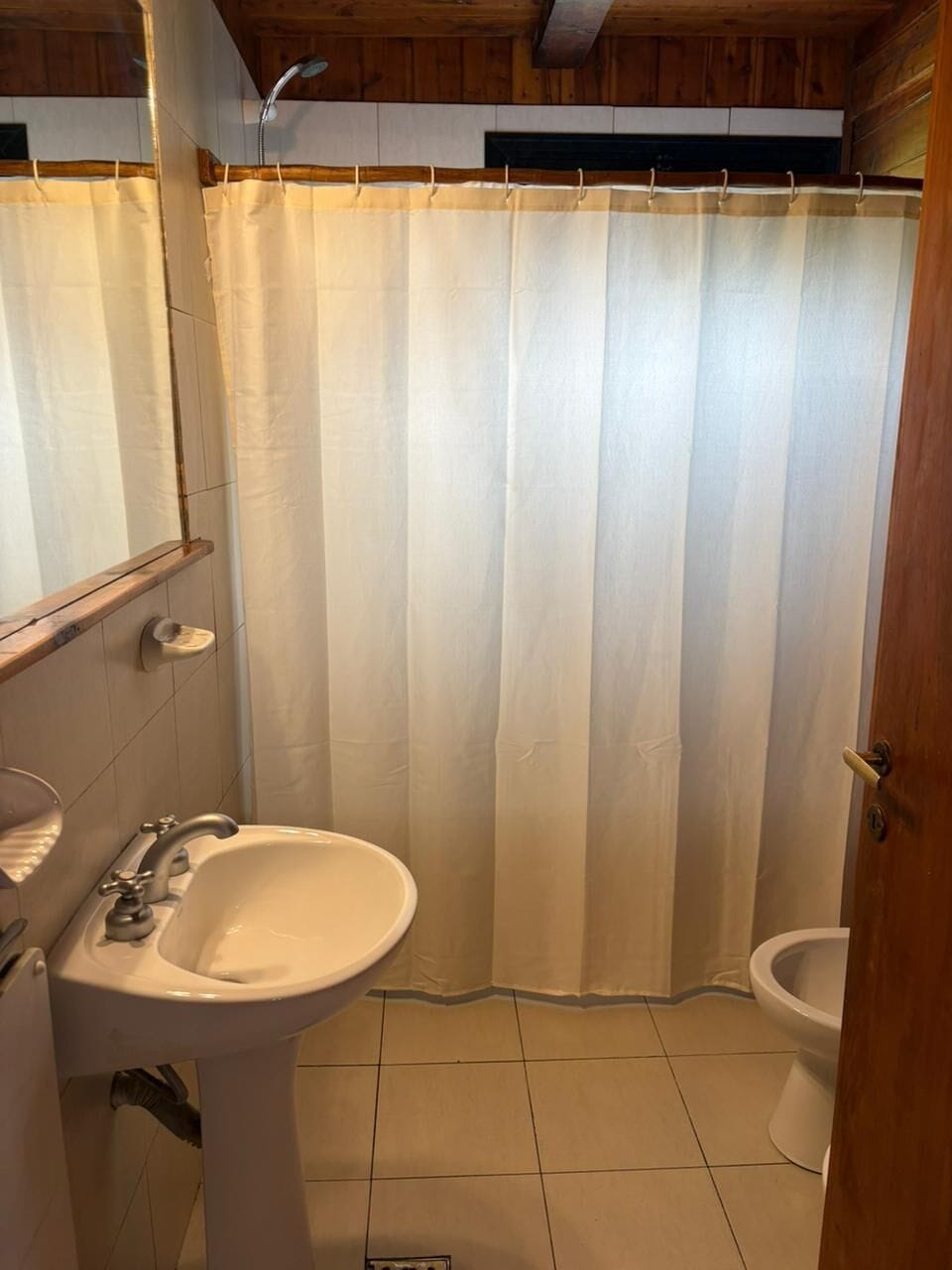 A bathroom with a shower curtain, a sink, and a toilet.