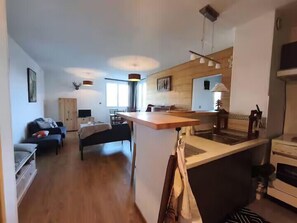 A compact living space with a kitchenette, a dining area, and a seating area. - Le Sauze: Bright 60m² Flat near Slopes (Enchastrayes)