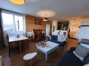 A cozy living room with a dining area, a kitchen, and a view of the outdoors. - Le Sauze: Bright 60m² Flat near Slopes (Enchastrayes)